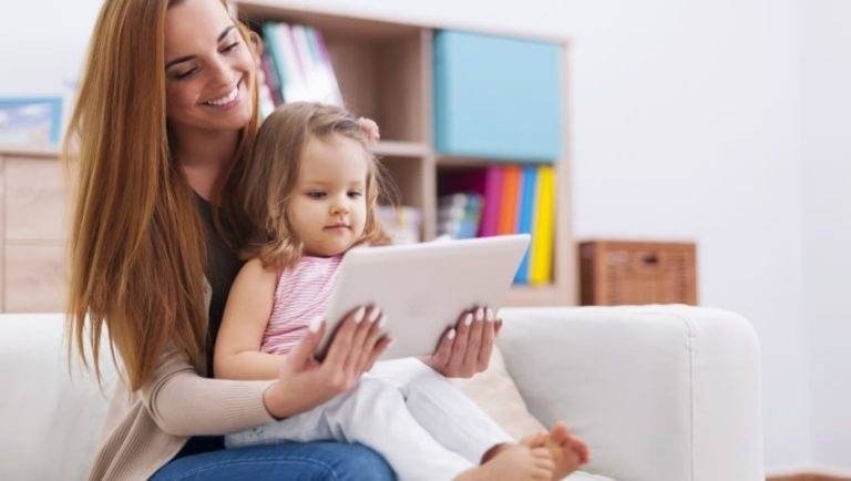 Mother and daughter using a tablet together on the couch