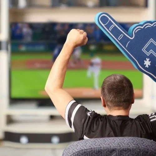 Sports fan celebrating while watching a game on cable TV